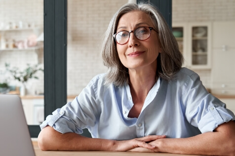 Middle aged woman sitting at a table smiling